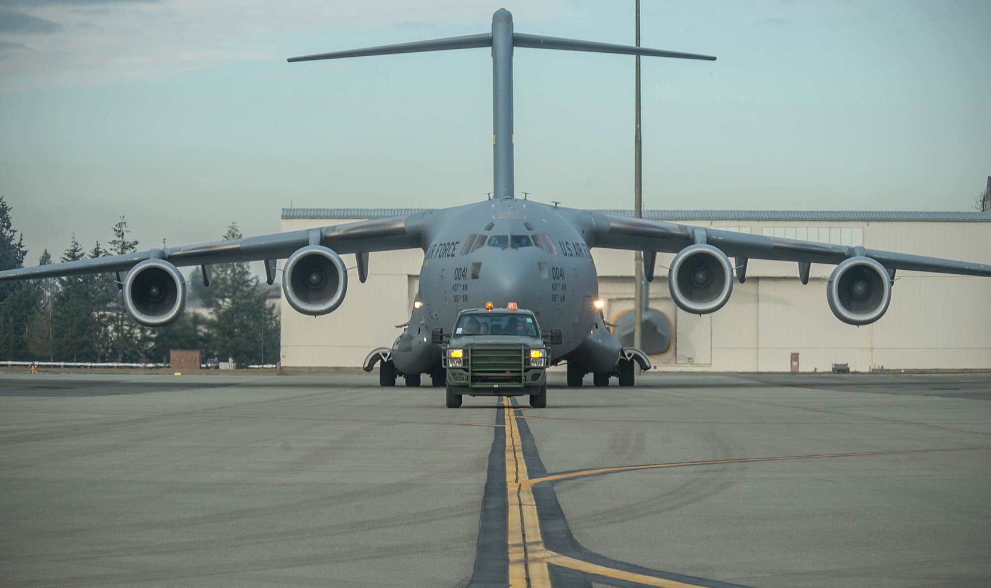 Ramp coordinators from the 821st Contingency Response Squadron, lead a C-17 Globemaster III to its parking spot, Jan. 24, 2017, at Joint Base Lewis-McChord, Washington. Airmen from the 821st Contingency Response Group, exercised their capability to support humanitarian efforts during exercise Dragon Breath at JBLM and Fairchild Air Force Base. (U.S. Air Force photo by Staff Sgt. Robert Hicks)