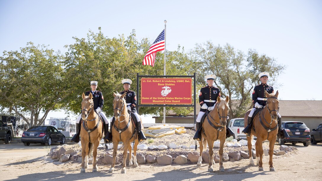 The Marine Corps' Mounted Color Guard post for a portrait at the stables, aboard the Marine Corps Logistics Base Barstow's Yermo Annex, Calif., Nov. 3. Left to right: Sgt. Monica Hilpisch, Sgt. Moses Machuca, Sgt. Terry Barker and Sgt. Jacob Cummins.