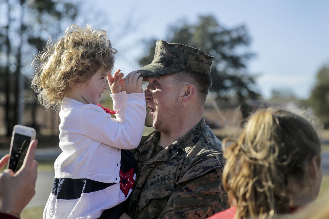 A Marine embraces his family as he returns to Camp Lejeune, N.C., Jan 23, 2017. The Marine is assigned to the Special Purpose Marine Air-Ground Task Force Crisis Response Africa. The unit supports operations, contingencies and security cooperation in the U.S. Africa Command area of responsibility. Marine Corps photo by Cpl. Alexander Mitchell