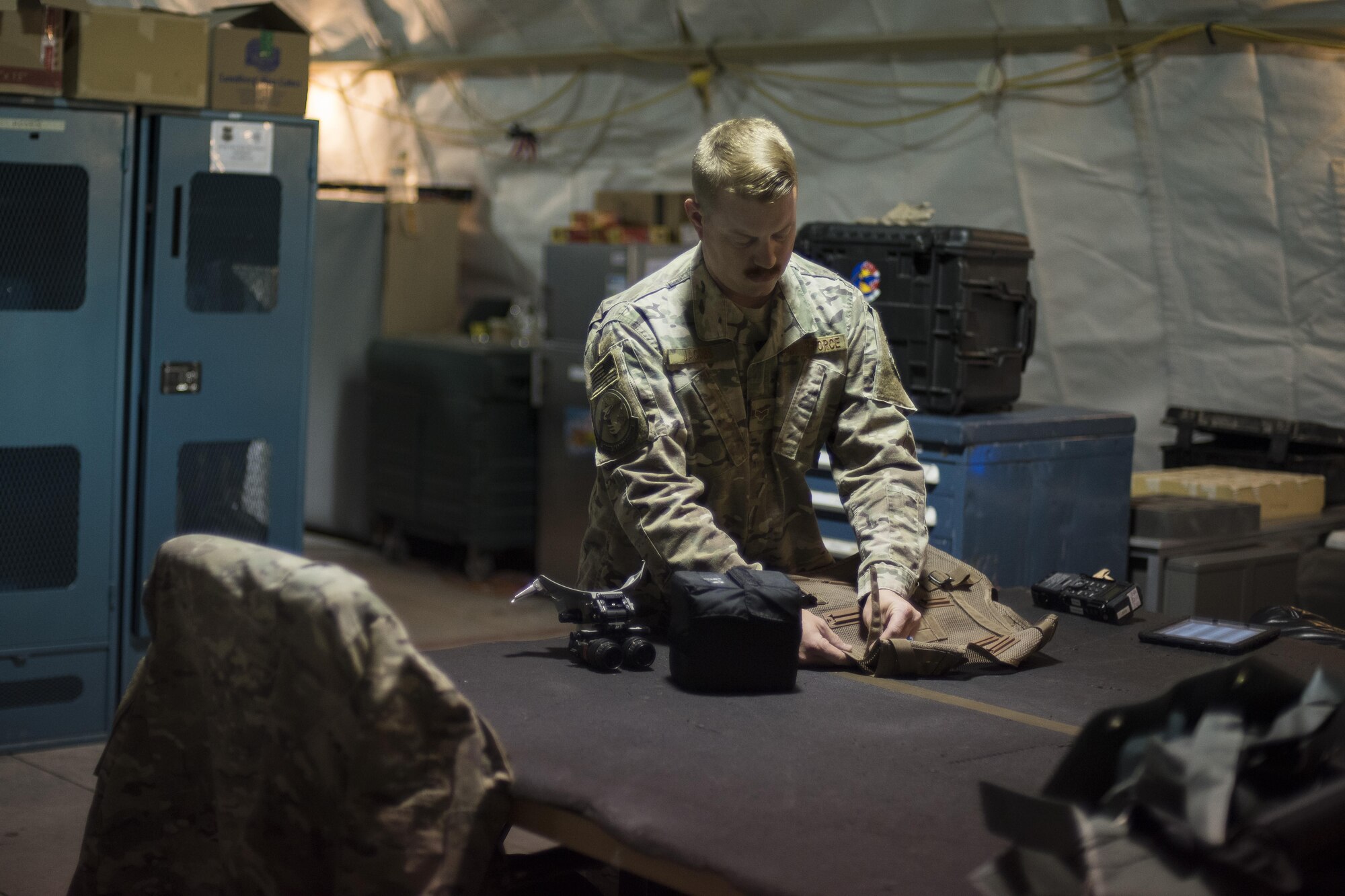 Senior Airman Aaron Jacobs, 332nd Aircrew Flight Equipment technician, inspects a survival vest June 12, 2017, in Southwest Asia. Members of AFE shop manage a variety of gear including helmets, G-suits and night vision goggles. (U.S. Air Force photo/Senior Airman Damon Kasberg)