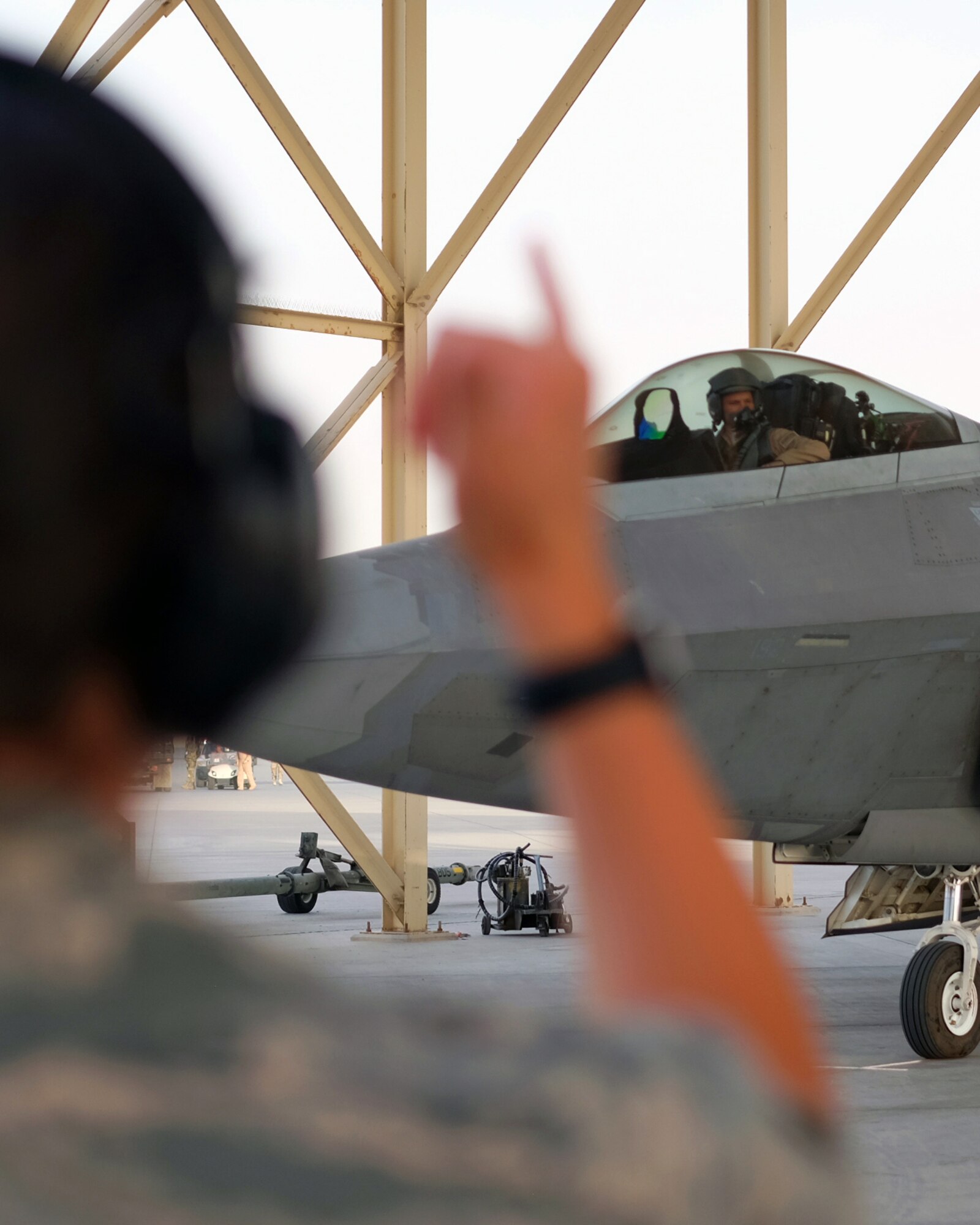 1st Lt. Erin, 380th Expeditionary Aircraft Maintenance Squadron Raptor Aircraft Maintenance Unit officer in-charge, signals to Brig. Gen. Charles S. Corcoran, 380th Air Expeditionary Wing commander, after his fini-flight June 30, 2017, at an undisclosed location in southwest Asia. Corcoran’s last flight with the 380 AEW follows an Air Force tradition dating back to World War II where upon completion of an aircrew member’s final flight they are doused with water and congratulated by their comrades in arms. (U.S. Air Force photo by Senior Airman Preston Webb)