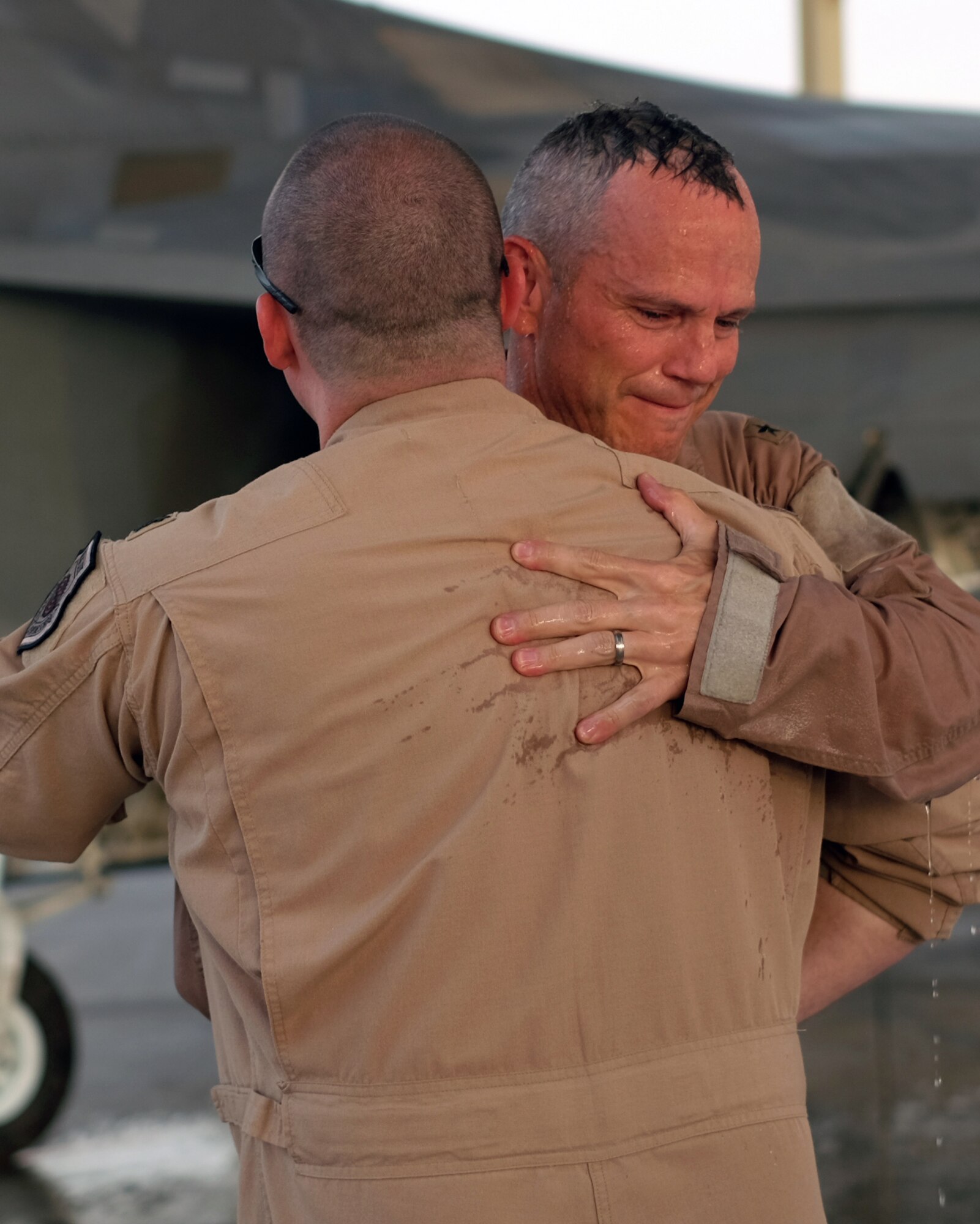 Brig. Gen. Charles S. Corcoran, 380th Air Expeditionary Wing commander, embraces Lt. Col. "Shell", 27th Expeditionary Fighter Squadron commander, at his fini-flight June 30, 2017, at an undisclosed location in southwest Asia. Shell, an F-22 pilot himself, has known the general since Corcoran was a major. (U.S. Air Force photo by Senior Airman Preston Webb)