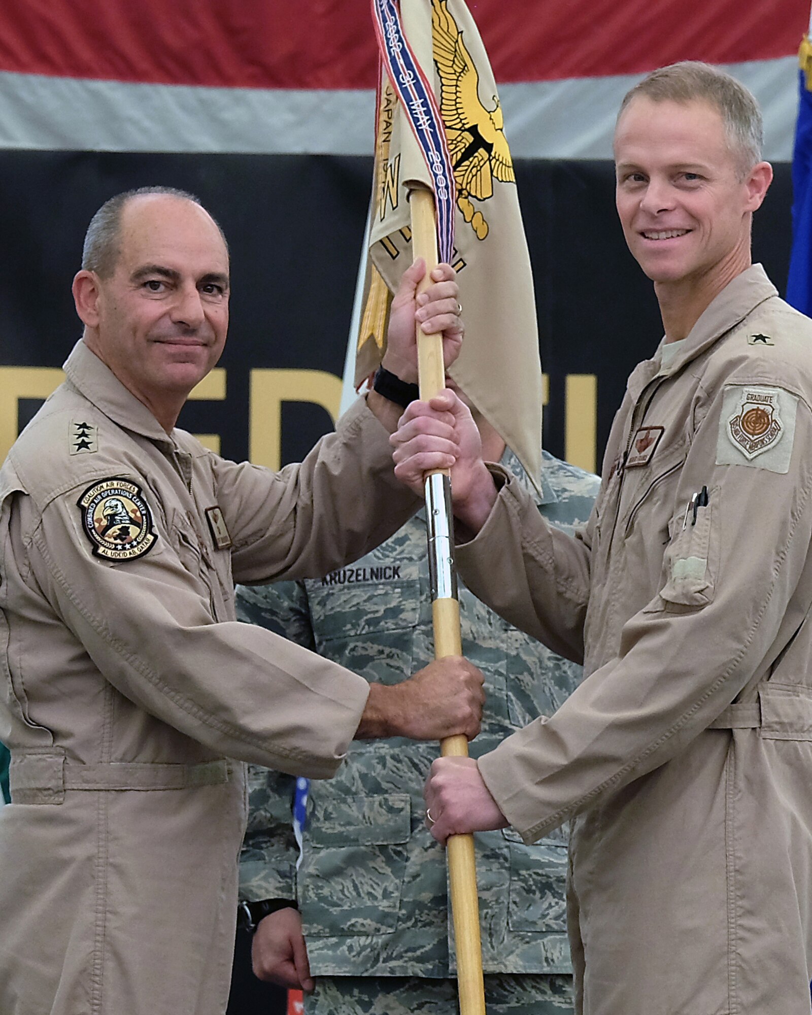 From right, Brig. Gen. Charles S. Corcoran, outgoing 380th Air Expeditionary commander, passes the 380 AEW guidon to Lt. Gen. Jeffrey L. Harrigian, U.S. Air Forces Central Command commander, during a change of command ceremony July 1, 2017, at an undisclosed location in southwest Asia. Change of command ceremonies, which afford troops an introduction to their new commander, date back to Frederick the Great of Prussia. (U.S. Air Force Photo by Senior Airman Preston Webb)