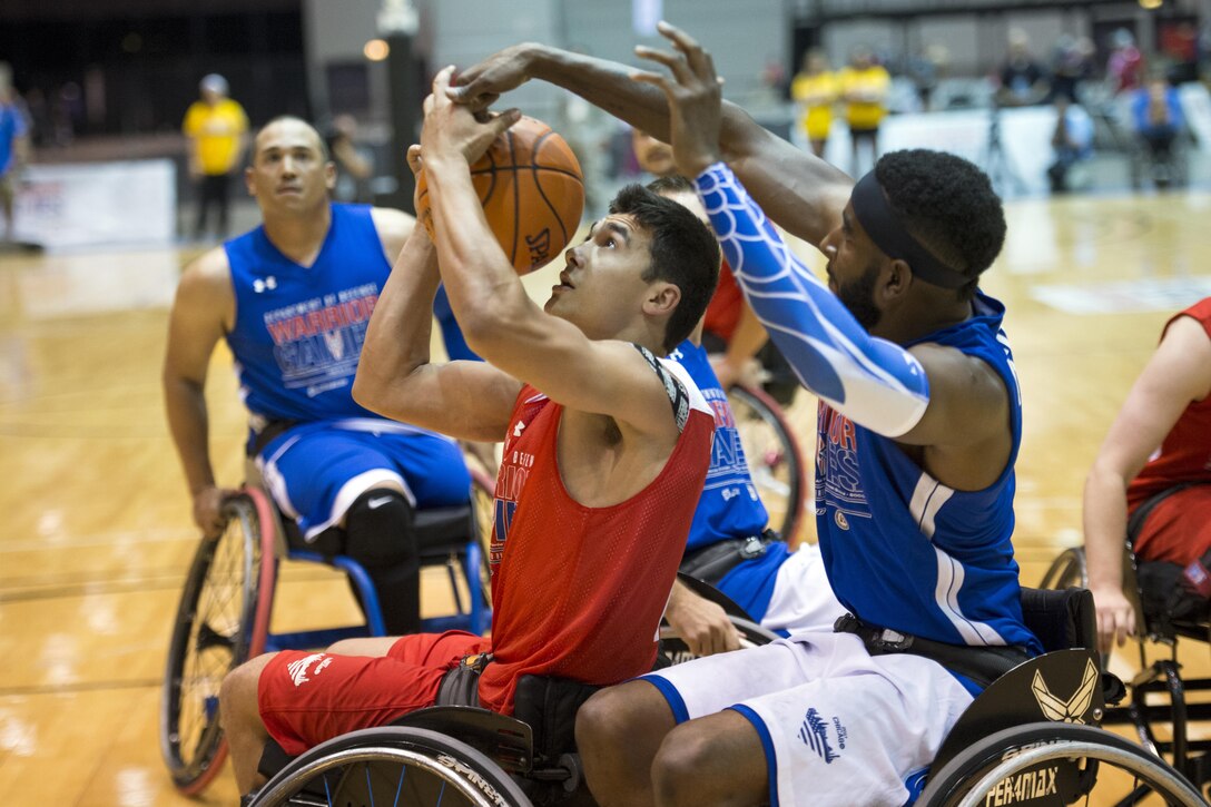 Marine Corps Lance Cpl. Robert Anfinson Jr. battles three other players for a rebound during wheelchair basketball.