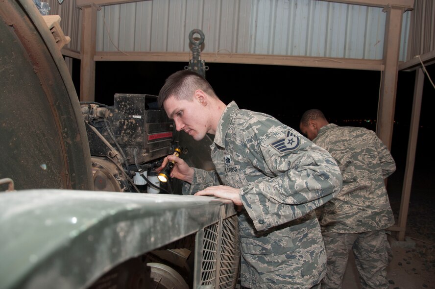 Staff Sgt. Michael Weixlmann, a power production specialist assigned to the 386th Expeditionary Civil Engineer Squadron, (left) conducts and inspection on a mobile aircraft arresting system at an undisclosed location in southwest Asia, June 24, 2017. A visual inspection is performed on these units daily. (U.S. Air Force Photo by Master Sgt. Eric M. Sharman)
