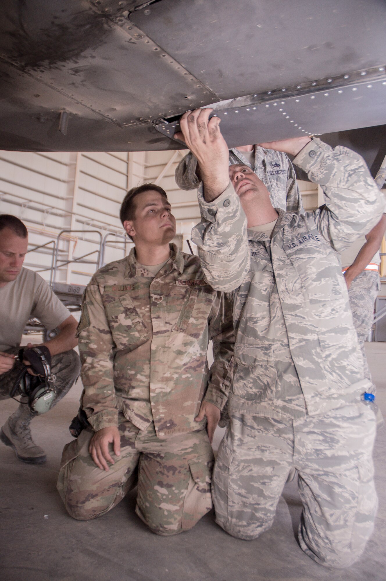 Master Sgt. Daniel Taylor, 386th Expeditionary Maintenance Squadron combat metals flight chief, checks a newly repaired C-130H landing gear door for fit after installation as Senior Airman Andrew Williams, a combat metals team member, looks on during an installation operation at an undisclosed location in Southwest Asia, June 23, 2017. (U.S. Air Force photo by Master Sgt. Eric M. Sharman)