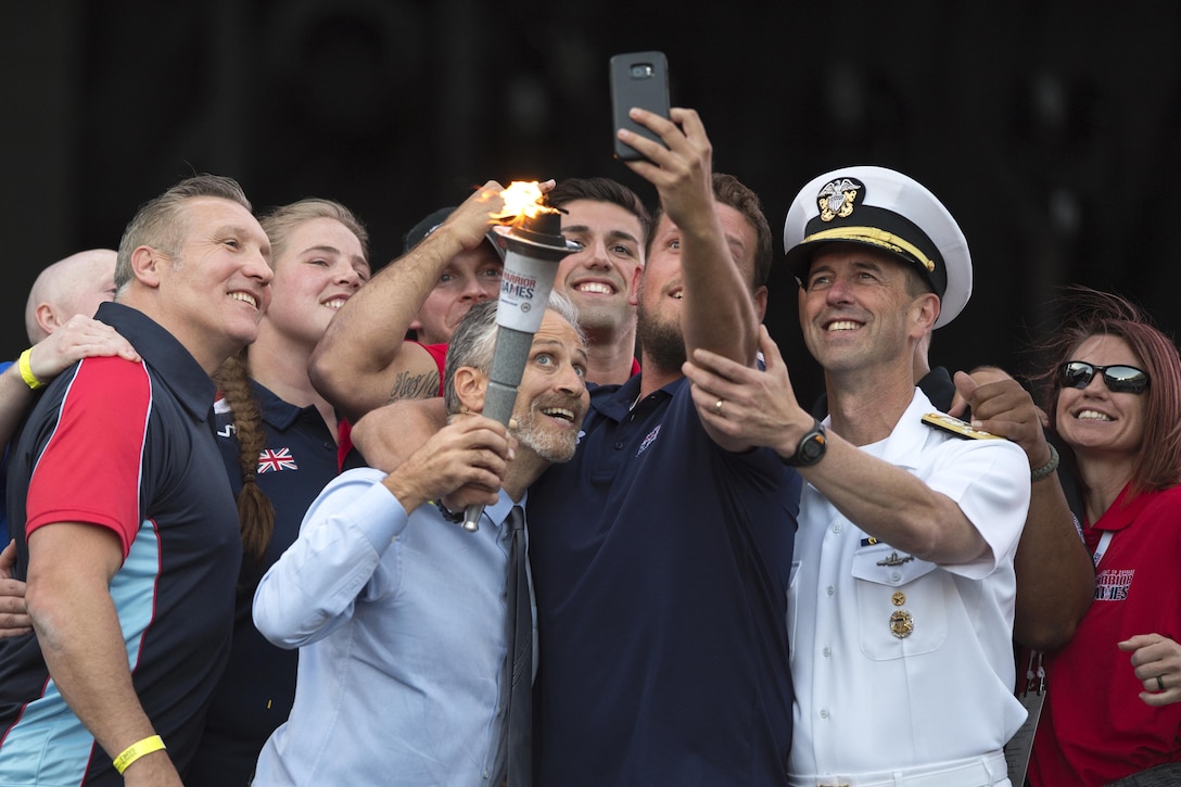 Television and movie personality, director, and writer Jon Stewart poses for a selfie with Chief of Naval Operations Adm. John M. Richardson and wounded warrior athletes during opening ceremonies for the 2017 Department of Defense Warrior Games at Soldier Field in Chicago, July 1, 2017. DoD photo by EJ Hersom