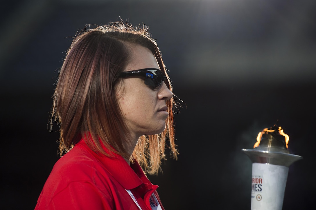 Marine Corps veteran Sarah Rudder carries the 2017 Department of Defense Warrior Games torch into Soldier Field in Chicago, July 1, 2017. DoD photo by EJ Hersom