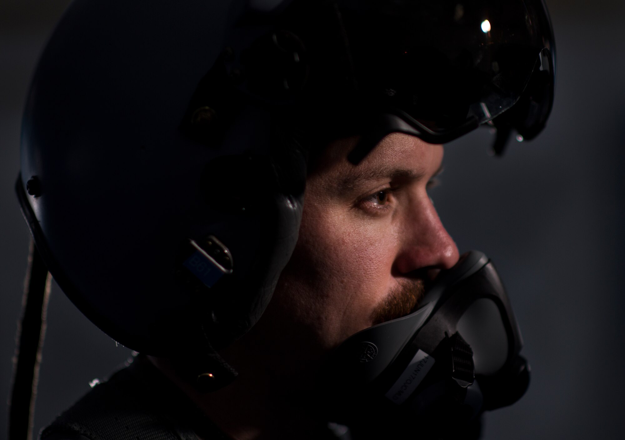 A U.S. Air Force pilot with the 332nd Air Expeditionary Wing, demonstrates the headgear aircrew must wear while flying June 13, 2017, in Southwest Asia. The Belgian Medical Component treated aircrew from the 332nd AEW for pains associated with flying high performance aircraft and weight from the equipment they carry. (U.S. Air Force photo/Senior Airman Damon Kasberg)