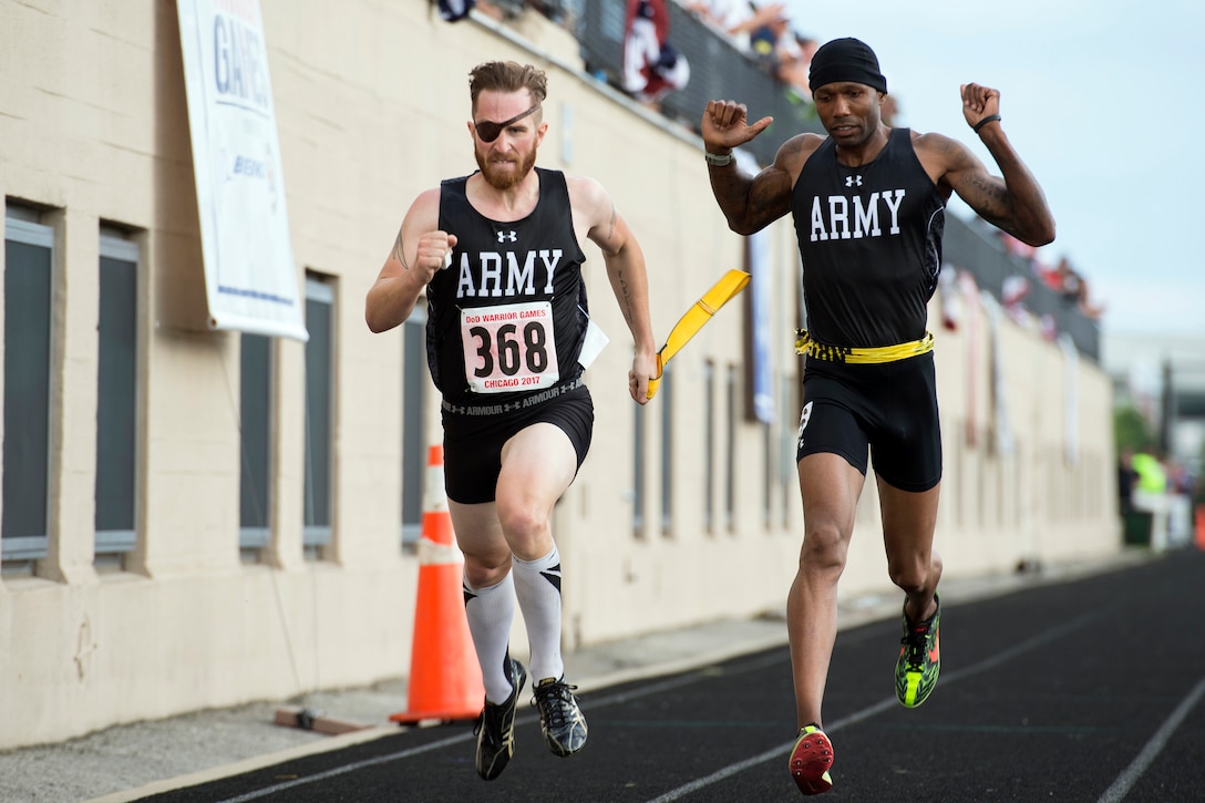 Visually impaired runner retired Army Spc. Michael Stephens, left, finishes a race with his guide retired Army Sgt. 1st Class Adam Blow trailing during the 2017 Department of Defense Warrior Games at Lane Technical College Preparatory High School in Chicago, July 2, 2017. The DoD Warrior Games are an annual event allowing wounded, ill and injured service members and veterans to compete in Paralympic-style sports. DoD photo by EJ Hersom