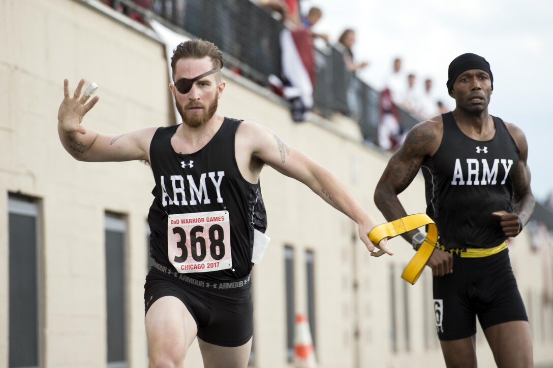 Visually impaired runner retired Army Spc. Michael Stephens finishes a race with his guide, retired Army Sgt. 1st Class Adam Blow, during the 2017 Department of Defense Warrior Games at Lane Technical College Preparatory High School in Chicago, July 2, 2017. DoD photo by EJ Hersom