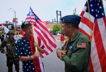 At right, the commander of the 932nd Airlift Wing's Operations Group, Col. Ray Smith, talks history with retired 932nd AW public affairs specialist Tech. Sgt. Daniel Oliver.  They and other wing Airmen past and present, met up early in the morning July 1, 2017, to assemble and prepare for the Saint Louis VP parade.  In talking about the unit they remembered wing lineage and special event memories before the start of the big "America's Birthday" VP parade in Saint Louis, Missouri.  The 932nd AW is a 22nd Air Force unit under Air Force Reserve Command.(U.S. Air Force photo by Lt. Col. Stan Paregien)