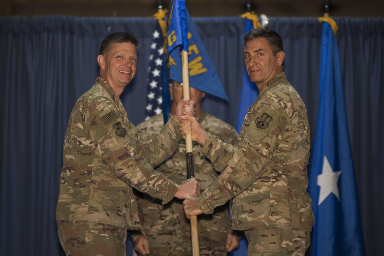 Col. John W. Chastain III, 332nd Expeditionary Maintenance Group commander, right, relinquishes the guidon to Brig. Gen. Kyle W. Robinson, 332nd Air Expeditionary Wing commander, during a change of command ceremony July 1, 2017 in Southwest Asia. The passing of a unit’s guidon symbolizes a transfer of command. (U.S. Air Force photo/Senior Airman Damon Kasberg)