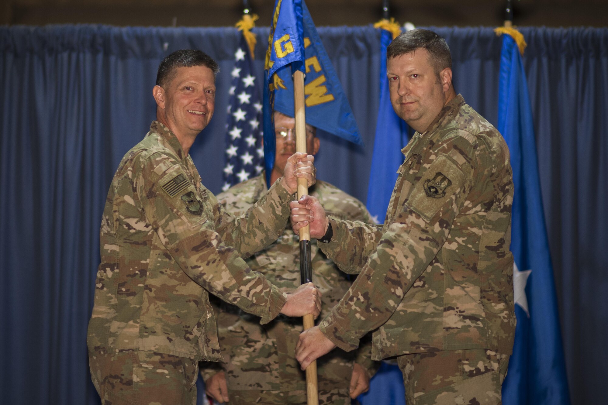 Brig. Gen. Kyle W. Robinson, 332nd Air Expeditionary Wing commander, left, passes the guidon to Col. Shane A. Barrett, during the 332nd Expeditionary Maintenance Group change of command ceremony July 1, 2017, in Southwest Asia. The passing of a guidon symbolizes a unit’s transfer of command. (U.S. Air Force photo/Senior Airman Damon Kasberg)