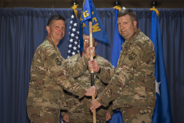 Brig. Gen. Kyle W. Robinson, 332nd Air Expeditionary Wing commander, left, passes the guidon to Col. Shane A. Barrett, during the 332nd Expeditionary Maintenance Group change of command ceremony July 1, 2017, in Southwest Asia. The passing of a guidon symbolizes a unit’s transfer of command. (U.S. Air Force photo/Senior Airman Damon Kasberg)