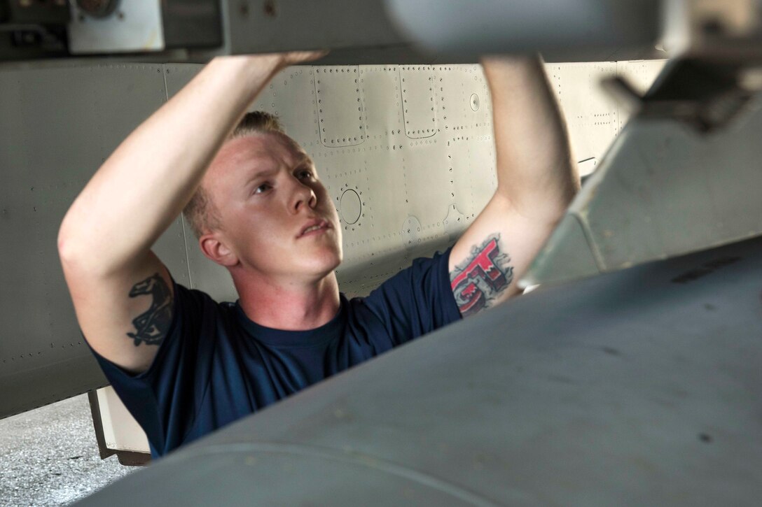 Air Force Senior Airman Dylan Hart arms an F-15 Eagle aircraft during a quarterly weapons load competition at Kadena Air Base, Japan, June 23, 2017. Hart is a weapons load team crew member assigned to the 44th Aircraft Maintenance Unit. Air Force photo by Senior Airman John Linzmeier