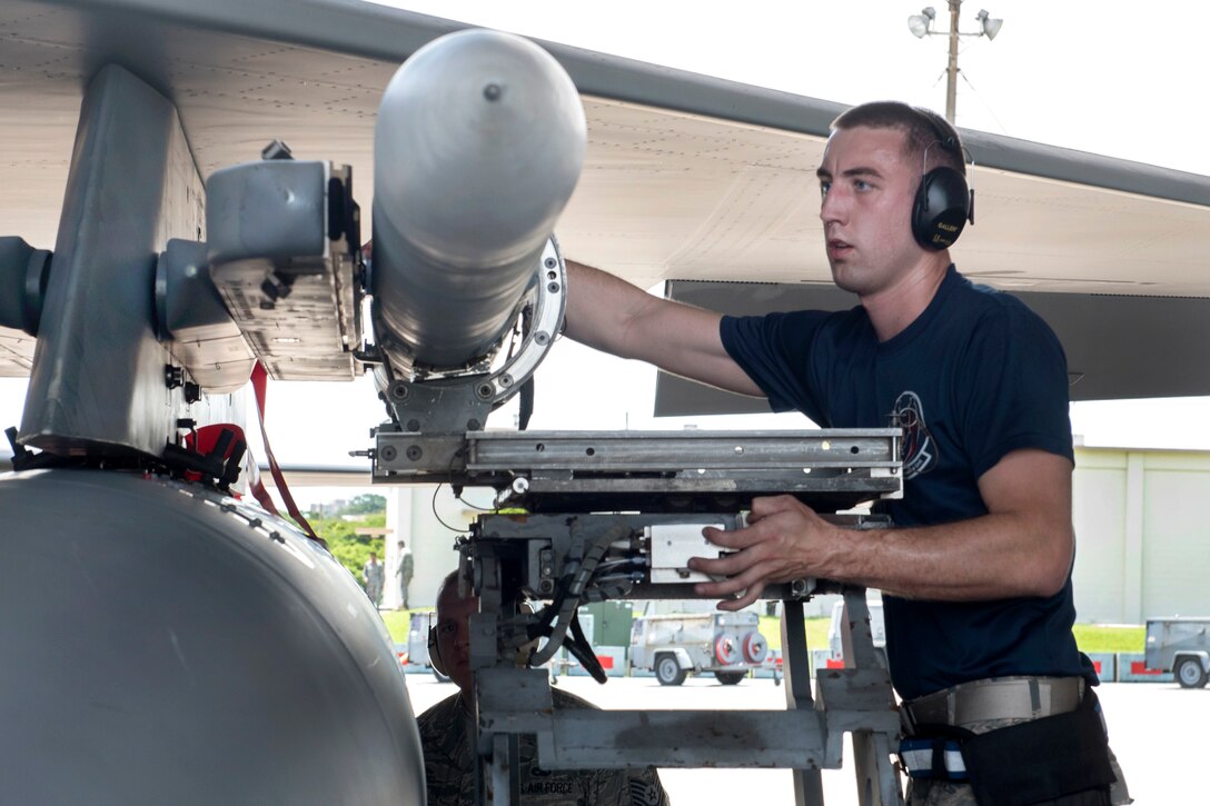Air Force Staff Sgt. Adam Schaetzl arms an F-15 Eagle aircraft during a quarterly weapons load competition at Kadena Air Base, Japan, June 23, 2017. Schaetzl is a weapons load team crew member assigned to the 44th Aircraft Maintenance Unit. Air Force photo by Senior Airman John Linzmeier