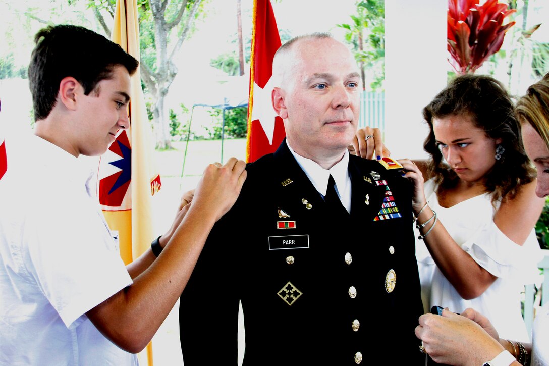The family of Army Chief Warrant Officer 5 Mark Parr, the command chief warrant officer for the 8th Theater Sustainment Command, pins his new rank shoulder boards in place during a promotion ceremony at Fort Shafter, Hawaii, May 31 2017. Army photo by Staff Sgt. Michael Behlin