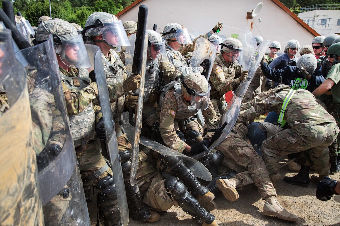 Soldiers repel role-playing hostile civilians conducting a riot control scenario during a Kosovo Force mission rehearsal exercise at the Joint Multinational Readiness Center in Hohenfels, Germany, June 30, 2017. Army photo by Spc. Randy Wren