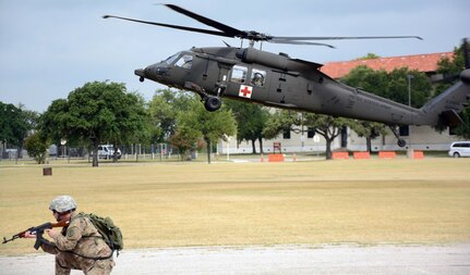 A Soldier assigned to the AMEDDC&S Training Support Activity defends while a UH-60 MEDEVAC lands to transport the wounded at Joint Base San Antonio-Fort Sam Houston June 30.