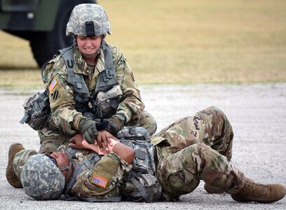 Combat medic Sgt. 1st Class Ashley Gilbert, from the Army Medical Department Non Commissioned Offers Academy, asseses the condition of an injured Soldier at Joint Base San Antonio-Fort Sam Houston June 30.