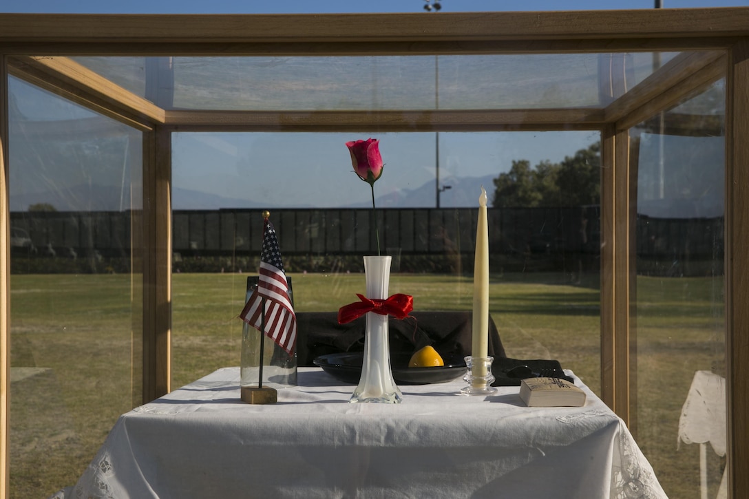 The Prisoner of War/Missing in Action table represents the service members who never had a chance to make it home or could not be found at the opening program of the Moving Vietnam Veterans Memorial Wall at Mission Springs Park in Desert Hot Springs, Calif., June 22, 2017. The Moving Wall, a scale model of the original Vietnam Veterans Memorial Wall, has the names of those men and women who were killed or missing in action etched onto a reflective stone, so visitors can not only see the names, but see themselves, reflecting on the lives of the people who fought and died to keep them safe. (U.S. Marine Corps photo by Cpl. Dave Flores)