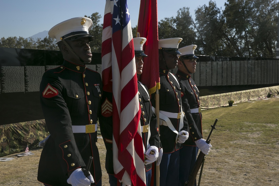 Marines with the Headquarters Battalion Color Guard prepare to present the colors during the opening program of the Moving Vietnam Veteran Memorial Wall at Mission Springs Park in Desert Hot Springs, Calif., June 22, 2017. The Moving Wall, a scale model of the original Vietnam Veterans Memorial Wall, has the names of those men and women who were killed or missing in action etched onto a reflective stone, so visitors can not only see the names, but see themselves, reflecting on the lives of the people who fought and died to keep them safe. (U.S. Marine Corps photo by Cpl. Dave Flores)
