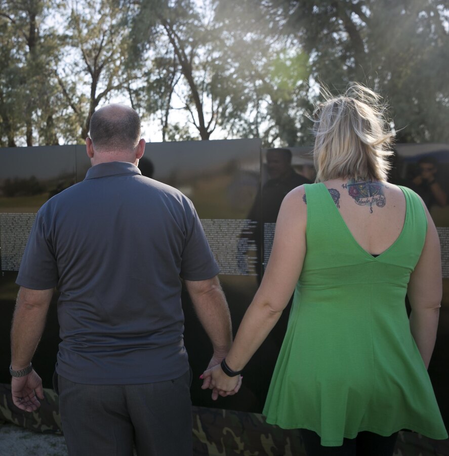 Scott Matas, mayor, Desert Hot Springs, stands with his wife, Victoria Matas, as they look at the names on the Moving Vietnam Veterans Memorial Wall during an opening program at Mission Springs Park in Desert Hot Springs, Calif., June 22, 2017. The Moving Wall, a scale model of the original Vietnam Veterans Memorial Wall, has the names of those men and women who were killed or missing in action etched onto a reflective stone, so visitors can not only see the names, but see themselves, reflecting on the lives of the people who fought and died to keep them safe. (U.S. Marine Corps photo by Cpl. Dave Flores)