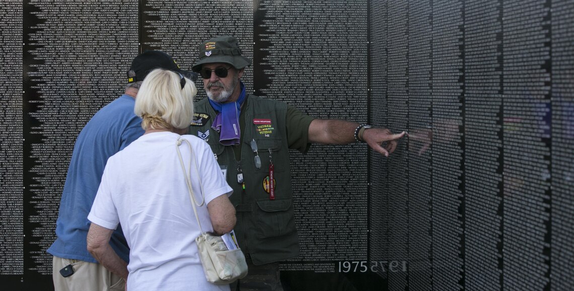 Retired Air Force Staff Sgt. Dennis Blessman speaks to visitors about the Moving Vietnam Veteran Memorial Wall after the opening program at Mission Springs Park in Desert Hot Springs, Calif., June 22, 2017 The Moving Wall, a scale model of the original Vietnam Veterans Memorial Wall, has the names of those men and women who were killed or missing in action etched onto a reflective stone, so visitors can not only see the names, but see themselves, reflecting on the lives of the people who fought and died to keep them safe. (U.S. Marine Corps photo by Cpl. Dave Flores)
