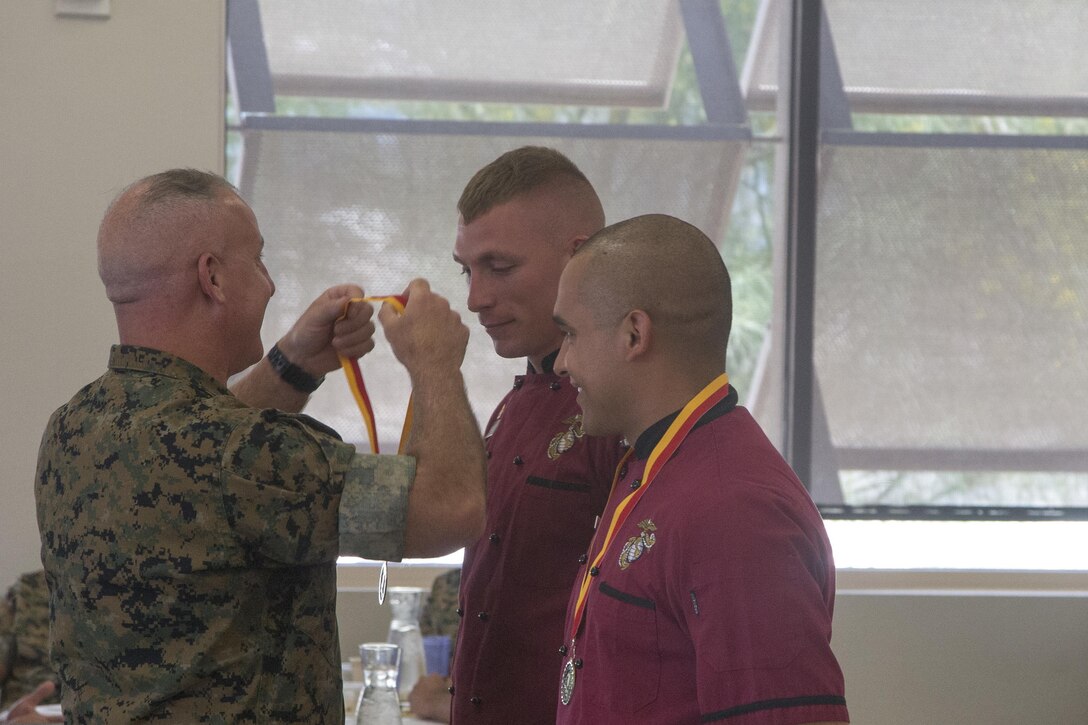 Lance Cpl. Carlos Amaya and Cpl. Tyler Faaborg, receive medals for winning the Chef of the Quarter competition at Phelps Mess Hall aboard Marine Corps Air Ground Combat Center Twentynine Palms, Calif., June 21, 2017. The team won both the Peoples’ Choice and the Judges’ Choice awards for this iteration of the competition. (U.S. Marine Corps photo by Cpl. Thomas Mudd)
