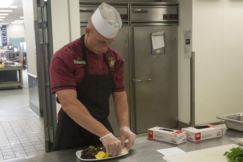 Cpl. Tyler Faaborg, Chef of the Quarter participant, readies one of his team’s dishes for judging during the Chef of the Quarter competition at Phelps Mess Hall aboard Marine Corps Air Ground Combat Center Twentynine Palms, Calif., June 21, 2017. The competition gave Marines and Sodexo chefs the ability to cook against each other in a friendly competition and break away from the very ridged routine schedule. (U.S. Marine Corps photo by Cpl. Thomas Mudd)