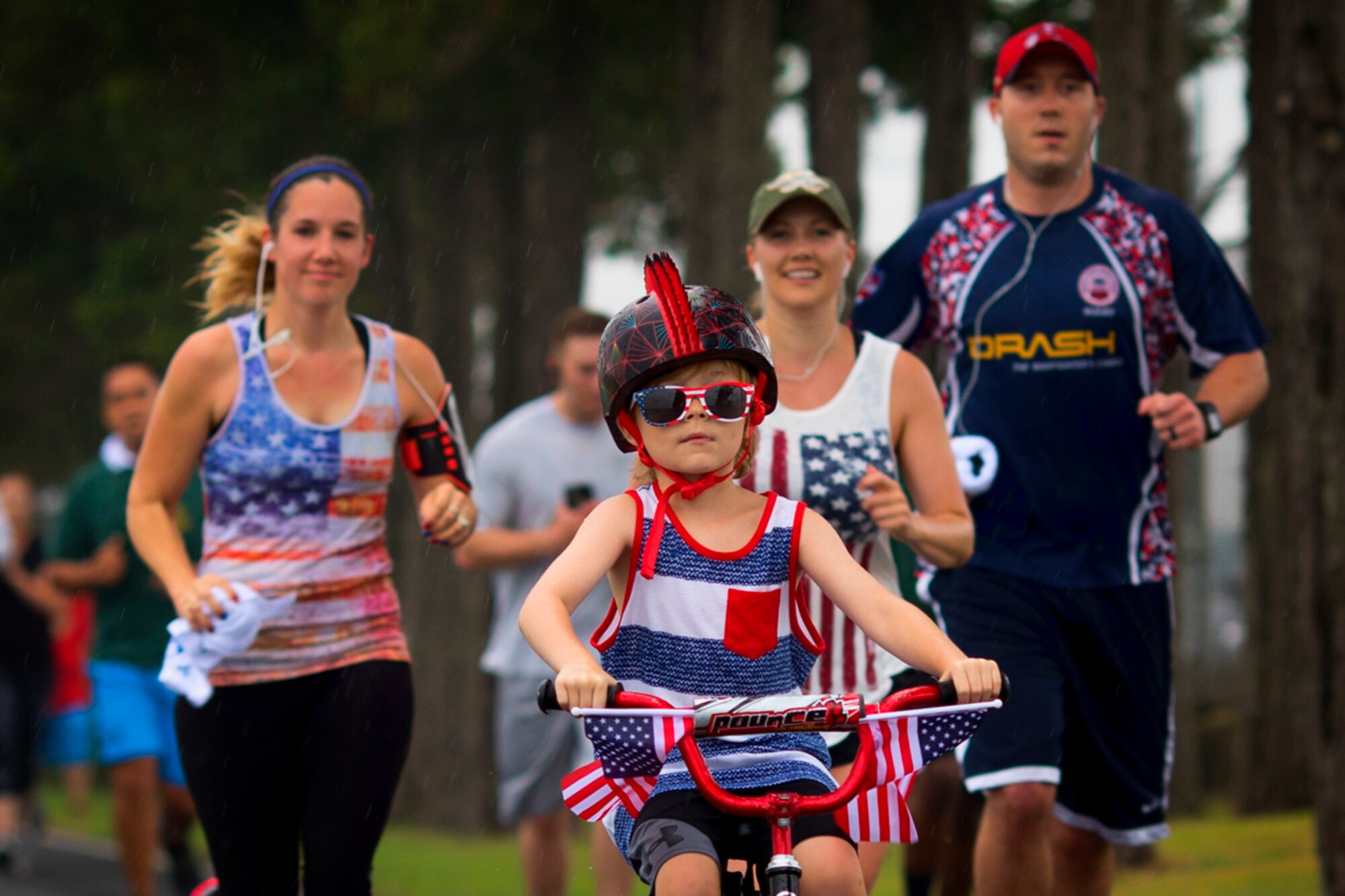 A child rides a patriotic themed bicycle during the Firecracker 5K run at Yokota Air Base, Japan, June 30, 2017. The 374th Force Support Squadron hosted events throughout the day to include a 5K Fun Run, the Leaky Son-Tiki race, cookie contest, live performances, water balloon toss, and fireworks. (U.S. Air Force photo by Yasuo Osakabe)