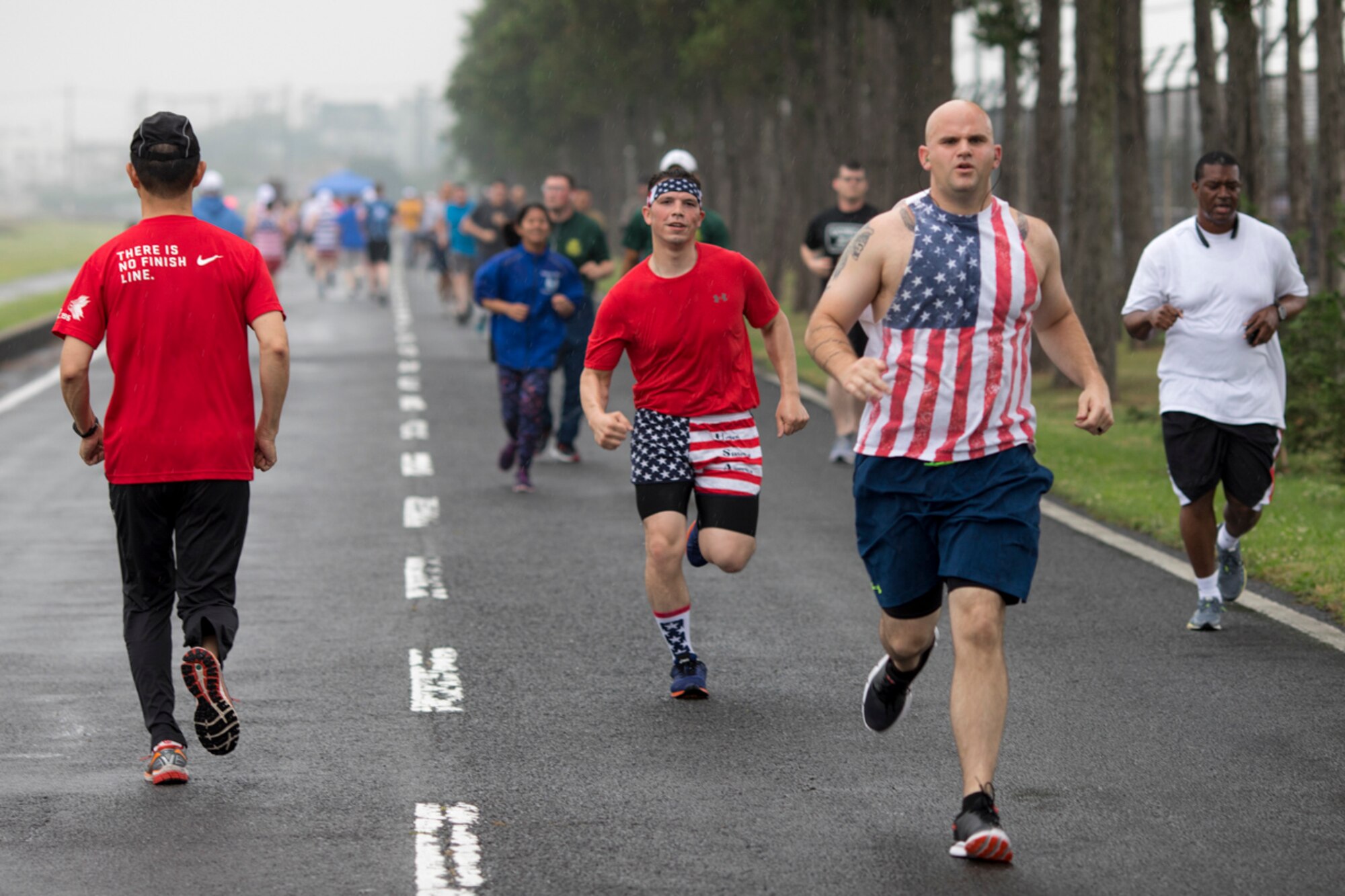 Airmen jog along the trail of the Firecracker 5K run, during the Celebrate America, June 30, 2017. Celebrate America provided Yokota personnel and their families the opportunity to relax and strengthen camaraderie while remembering America's independence. (U.S. Air Force photo by Yasuo Osakabe)