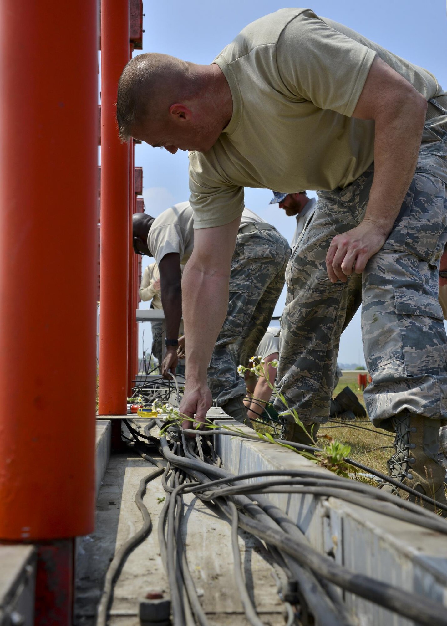 U.S. Air Force Master Sgt. Scott Griffith, 51st Operations Support Squadron Air Traffic Control Airfield Landing Systems section chief, helps remove a cable at Osan Air Base, Republic of Korea, June 22, 2017. Members of Team Osan’s 51st OSS and 51st Civil Engineer Squadron worked together to move an instrument landing system from the recently closed runway to the newly repaired runway. (U.S. Air Force photo by Airman 1st Class Gwendalyn Smith)