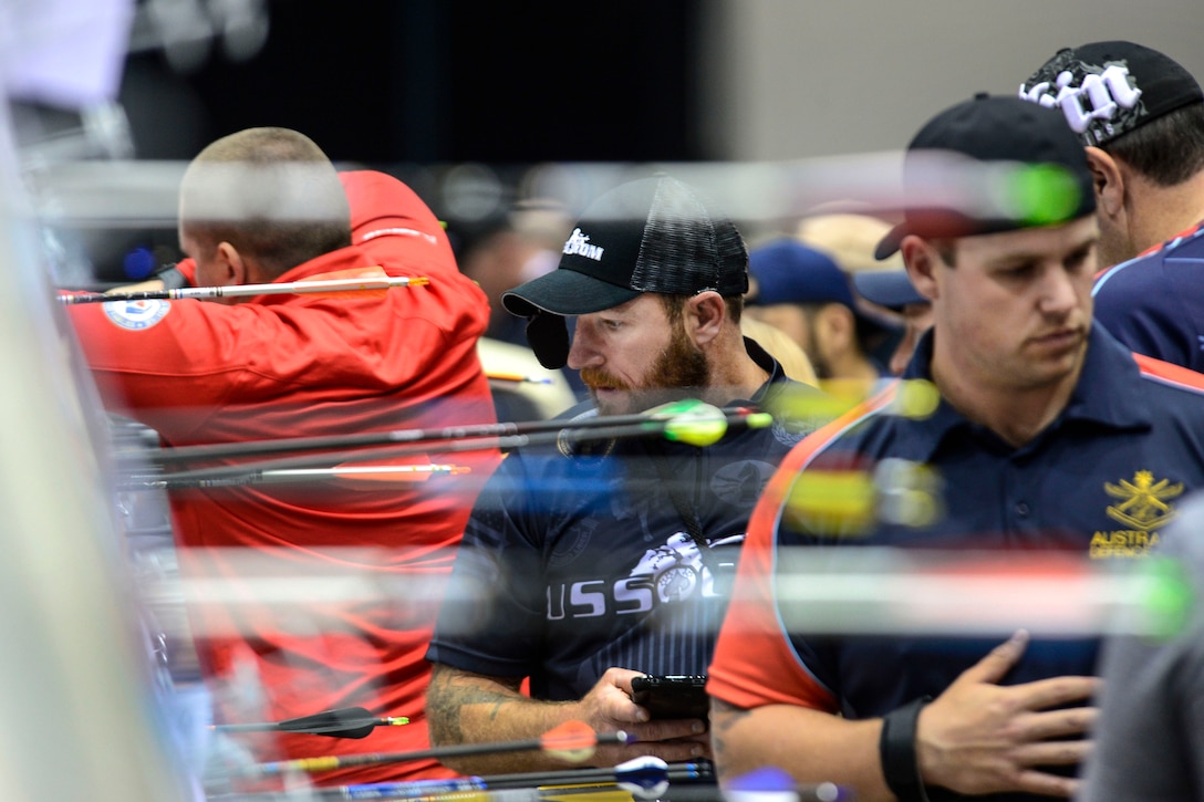Retired Army Sgt. 1st Class Josh Lindstrom, center, checks his target during the 2017 Department of Defense Warrior Games in Chicago, July 3, 2017. Lindstrom went on to win the gold medal in the compound bow event. Army photo by Michael Bottoms