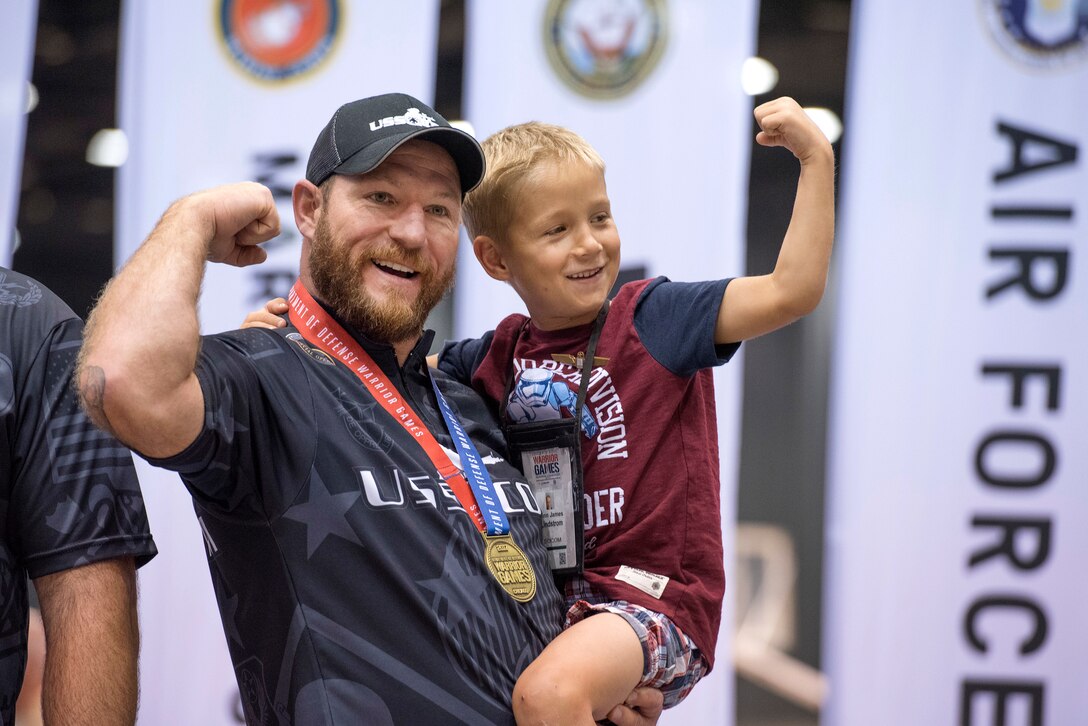 Retired Army Sgt. 1st Class Joshua Lindstrom of Team Special Operations Command, celebrates with his son Finn James Lindstrom, 8, after winning gold in compound archery during the 2017 Department of Defense Warrior Games in Chicago, July 3, 2017. DoD photo by Roger L. Wollenberg