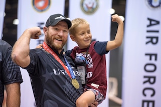 Retired Army Sgt. 1st Class Joshua Lindstrom of Team Special Operations Command, celebrates with his son Finn James Lindstrom, 8, after winning gold in compound archery during the 2017 Department of Defense Warrior Games in Chicago, July 3, 2017. DoD photo by Roger L. Wollenberg