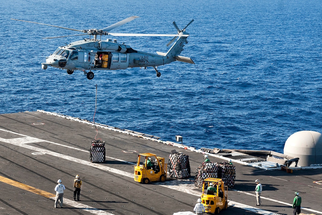 An MH-60S Seahawk helicopter delivers supplies on the flight deck of the aircraft carrier USS George H.W. Bush in the Mediterranean Sea, June 26, 2017. The helicopter crew is assigned to Helicopter Sea Combat Squadron 9. Navy photo by Petty Officer 3rd Class Mario Coto