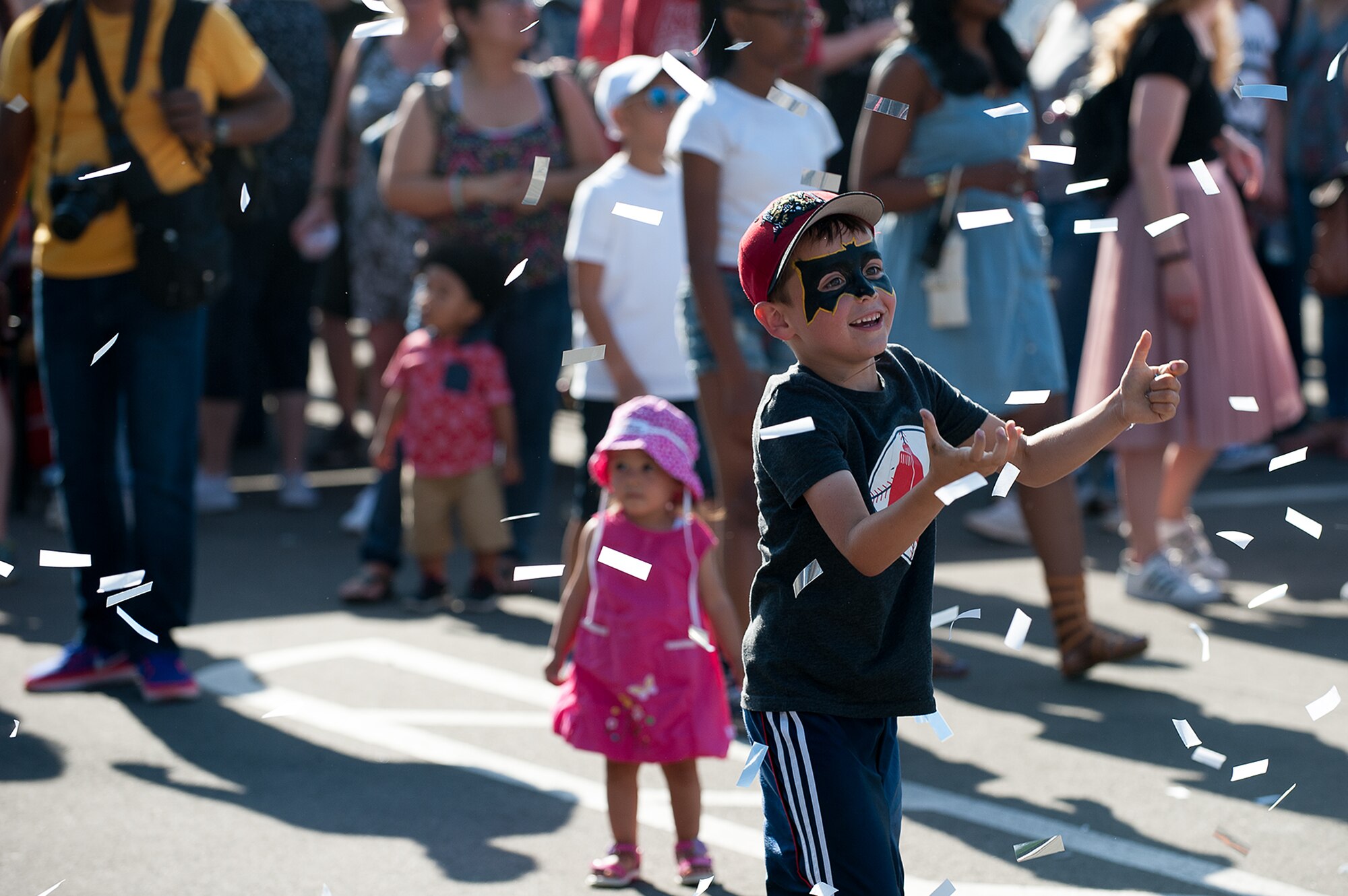 A Kaiserslautern Military Community child catches confetti during Freedom Fest at the Enlisted Club parking lot on Ramstein Air Base, Germany, July 4, 2017. A cover band shot the confetti at the crowd while playing a song as part of the Independence Day celebration. (U.S. Air Force photo by Senior Airman Devin Boyer)