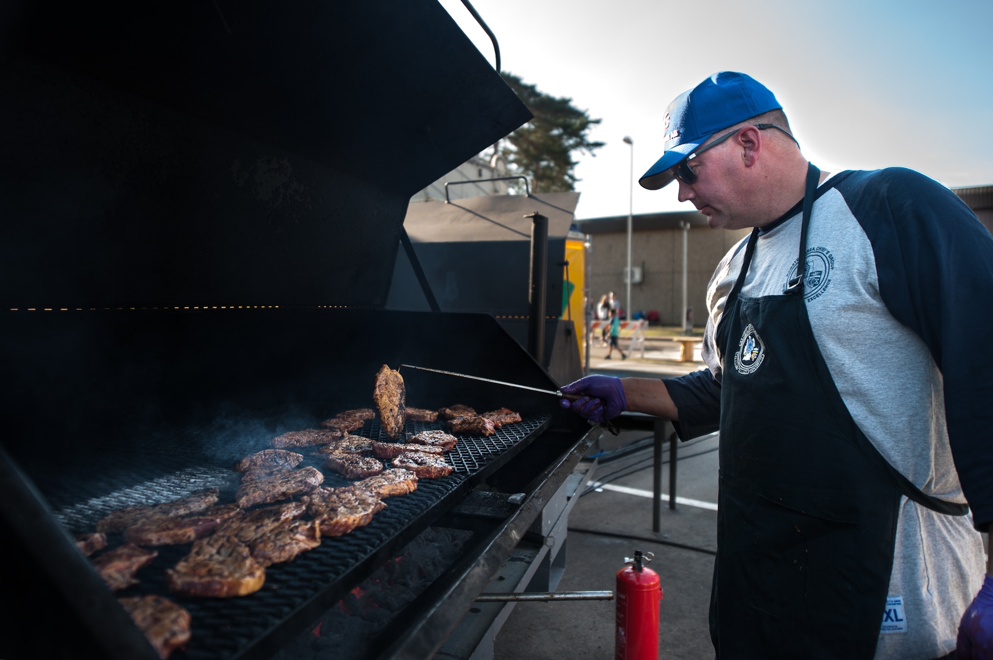 U.S. Air Force Chief Master Sgt. Jack Johns, 435th Contingency Response Squadron and Ramstein Area Chief’s Group member, grills pork shoulder during Freedom Fest at the Enlisted Club parking lot on Ramstein Air Base, Germany, July 4, 2017. The Chief’s Group, a non-profit organization, raised money by selling pork sandwiches during the event. All of their proceeds went back into the military community. (U.S. Air Force photo by Senior Airman Devin Boyer)