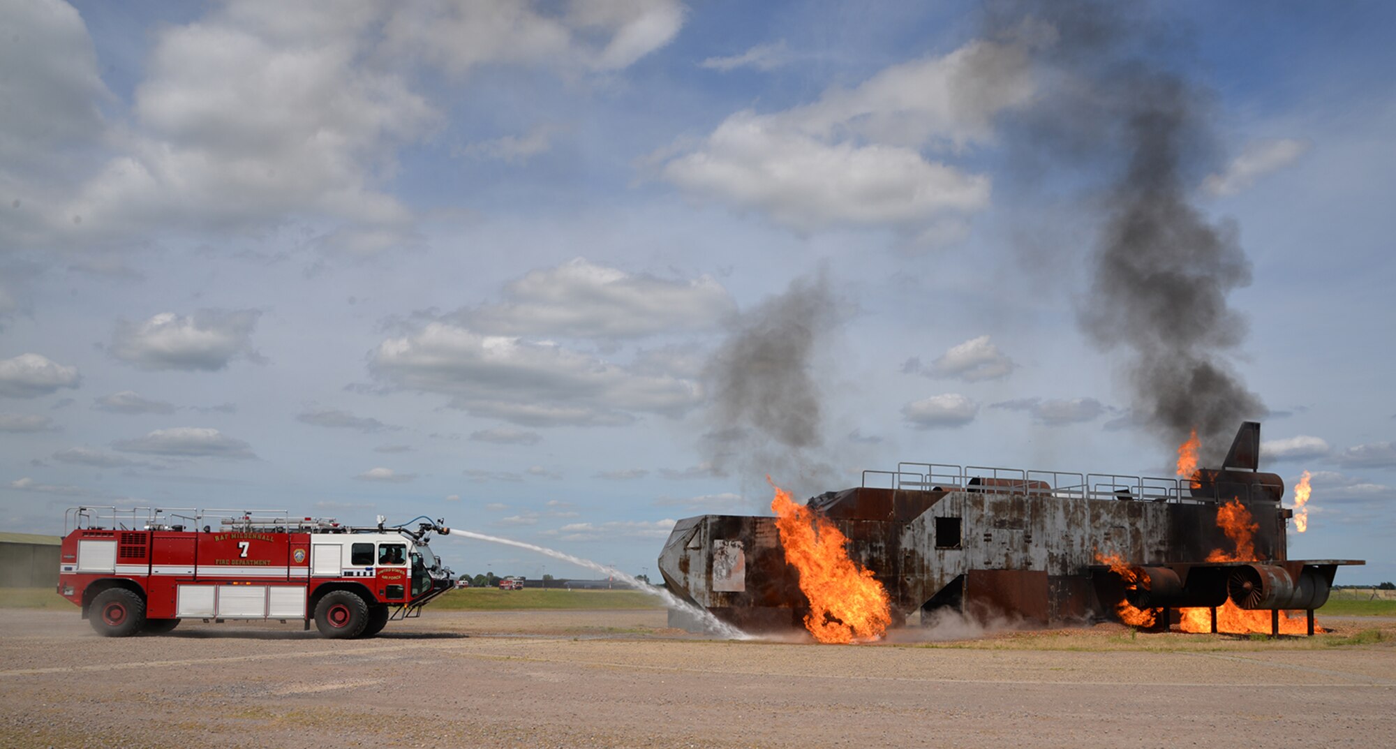 Host nation firefighters from Norfolk Fire and Rescue Service, most of whom are recruits at the end of their training course, train with 100th Civil Engineer Squadron firefighters June 26, 2017, at the live-fire trainer on RAF Mildenhall, England. They visited the base to gain familiarization training on KC-135 Stratotankers, which increased effective communication and networking between the on and off base fire departments. A mutual aid agreement between RAF Mildenhall and the community means U.S. Air Force emergency responders are able to assist in emergencies off base when required, and local first responders can offer help on base. The British first-responders would also usually be first on scene to any incident that happened off base. (U.S. Air Force photo by Karen Abeyasekere)