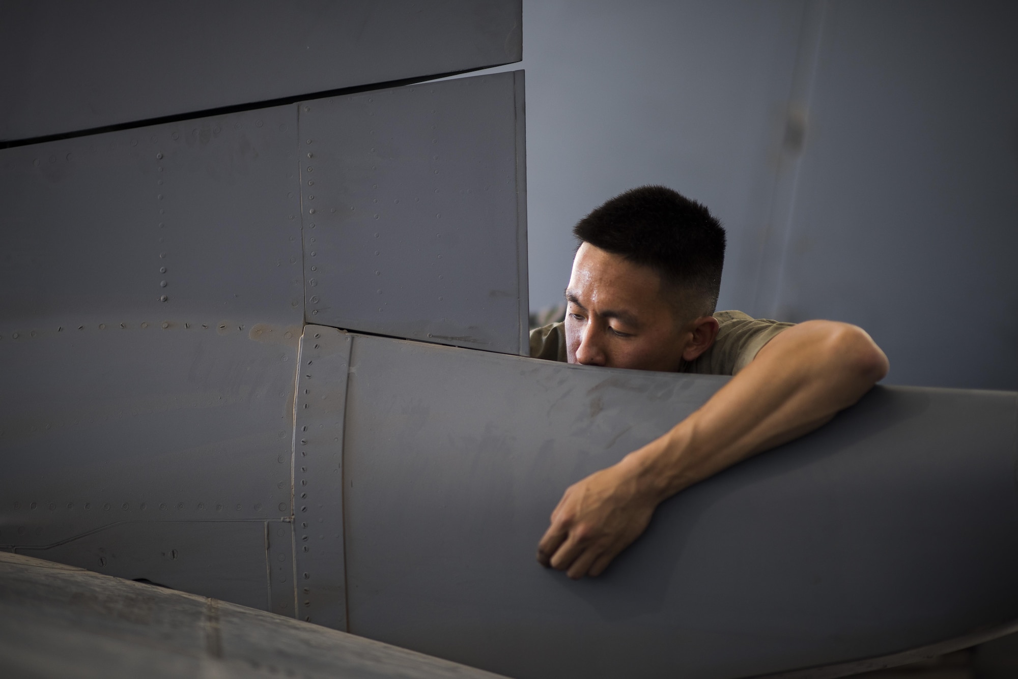 Airman 1st Class Samuel Kuo, 332nd Expeditionary Maintenance Squadron inspection section journeyman, replaces a worn horizontal stabilizer component on an F-15E Strike Eagle, June 16, 2017, in Southwest Asia. Maintainers work throughout the day and night to complete their job and ensure the F-15Es are operational. (U.S. Air Force photo/Senior Airman Damon Kasberg)