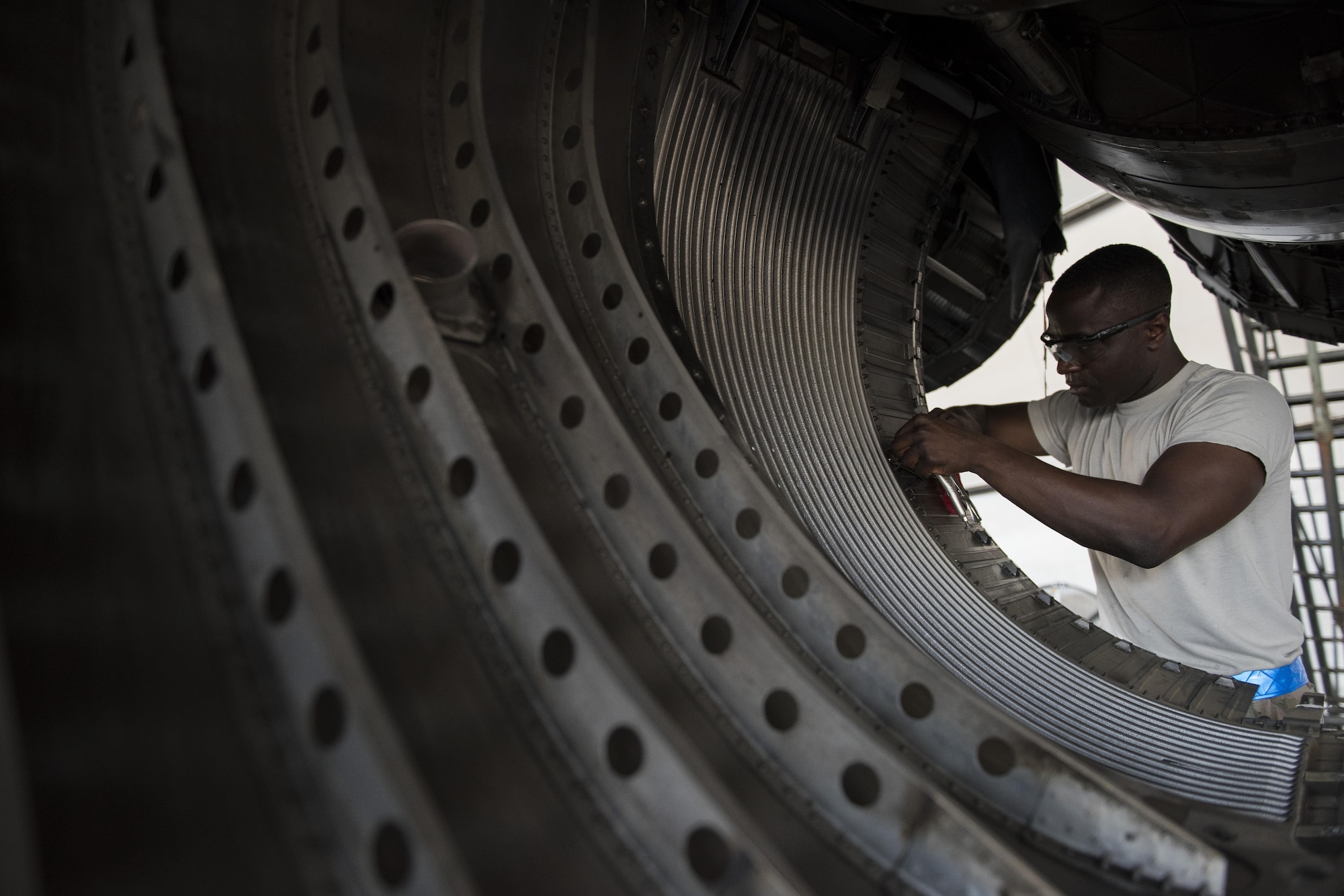 Senior Airman Babatunde Olatinwo, 332nd Expeditionary Maintenance Squadron aircraft structural maintenance journeyman, repairs a worn panel on an F-15E Strike Eagle, June 16, 2017, in Southwest Asia. F-15Es undergo detailed inspections and maintenance every 400 hours of flight. (U.S. Air Force photo/Senior Airman Damon Kasberg)