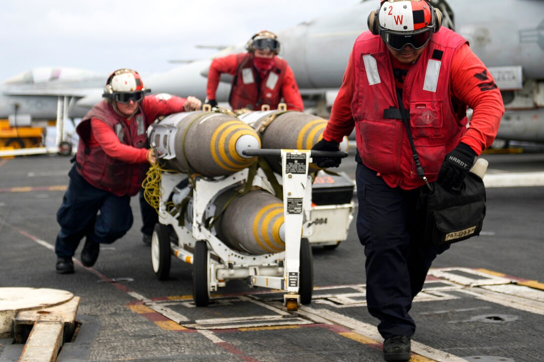 Sailors move ordnance across the flight deck of the aircraft carrier USS Nimitz in the Pacific Ocean, June 29, 2017. Navy photo by Petty Officer 3rd Class Leon Wong