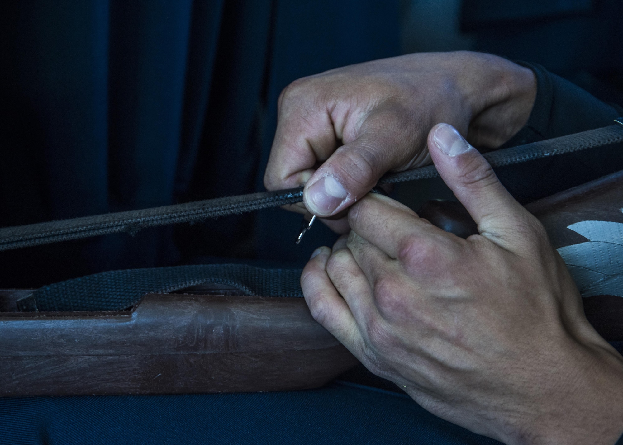 Airman 1st Class Charlie Vaa, U.S. Air Force Honor Guard Drill Team member, adjusts the strap of an M1 rifle stock before a performance at Sea World in San Diego, Ca., June 27, 2017. Not only does the drill team perform complex routines involving a choreographed sequence of weapon maneuvers, but they also maintain a sense of professionalism and pristine appearance when in uniform. (U.S. Air Force photo by Senior Airman Jordyn Fetter)