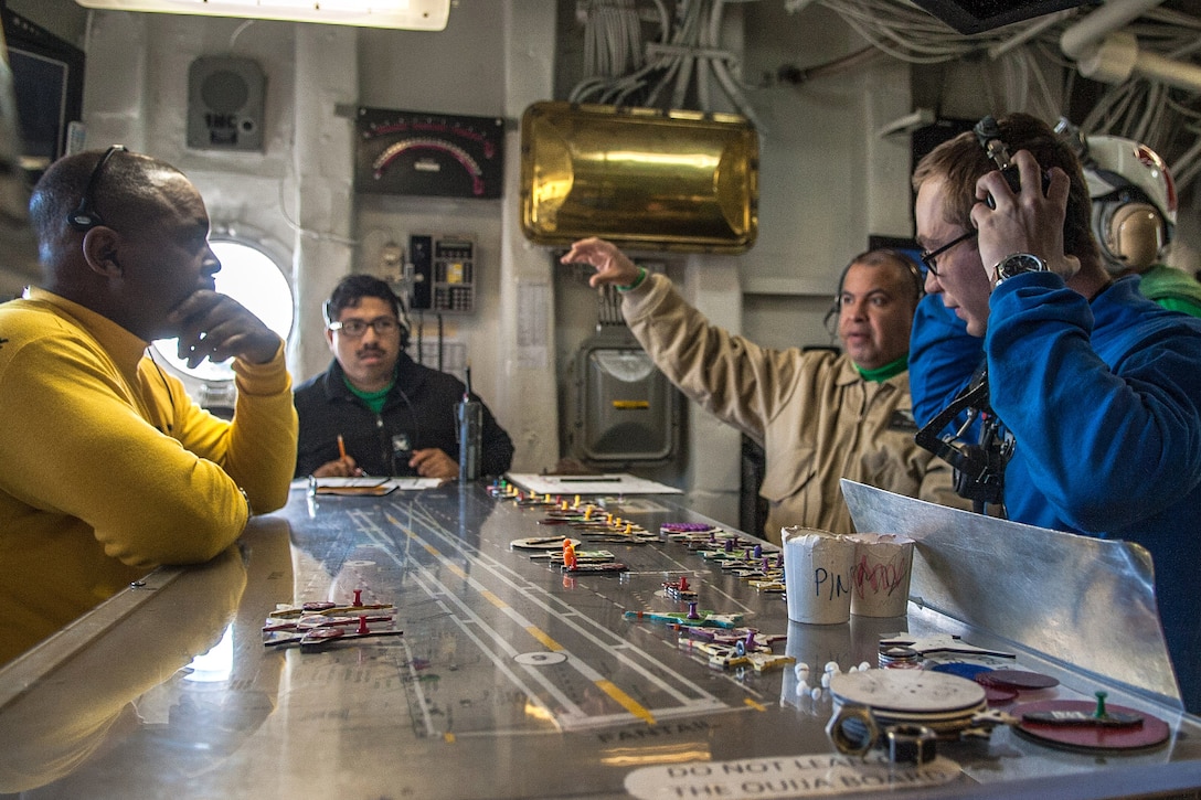 Sailors discuss flight operations from the flight deck control room aboard the aircraft carrier USS Ronald Reagan in western Pacific Ocean, June 26, 2017. Navy photo by Petty Officer 3rd Class Kaila Peters 