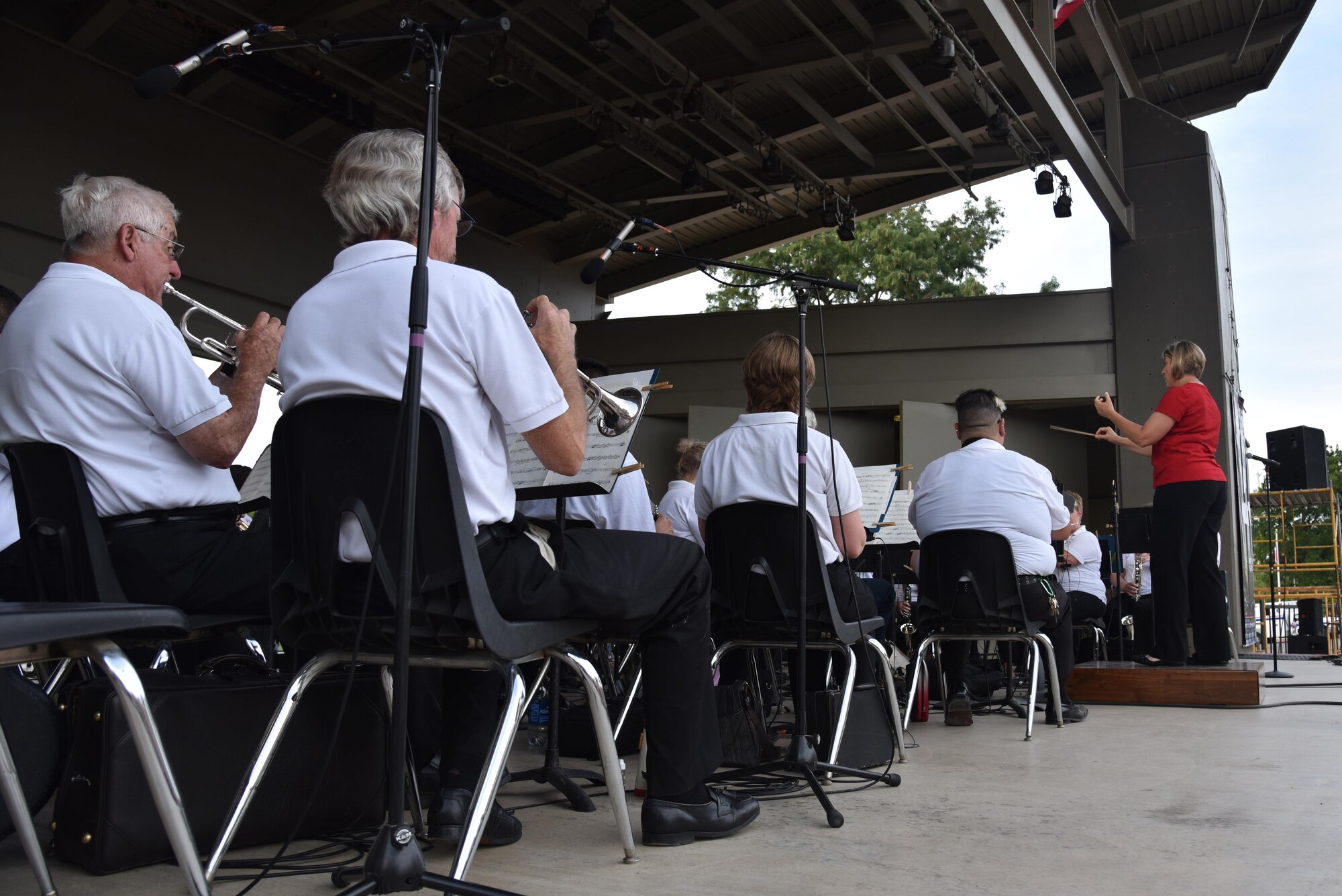 Constance Kelley, San Angelo Community Band director, conducts the community band at the 30th Annual San Angelo Symphony’s Pops Concert at the Bill Aylor Sr. Memorial RiverStage in San Angelo, Texas, July 3, 2017. The band played several patriotic songs before the San Angelo Symphony took over. (U.S. Air Force photo by Staff Sgt. Joshua Edwards/Released)