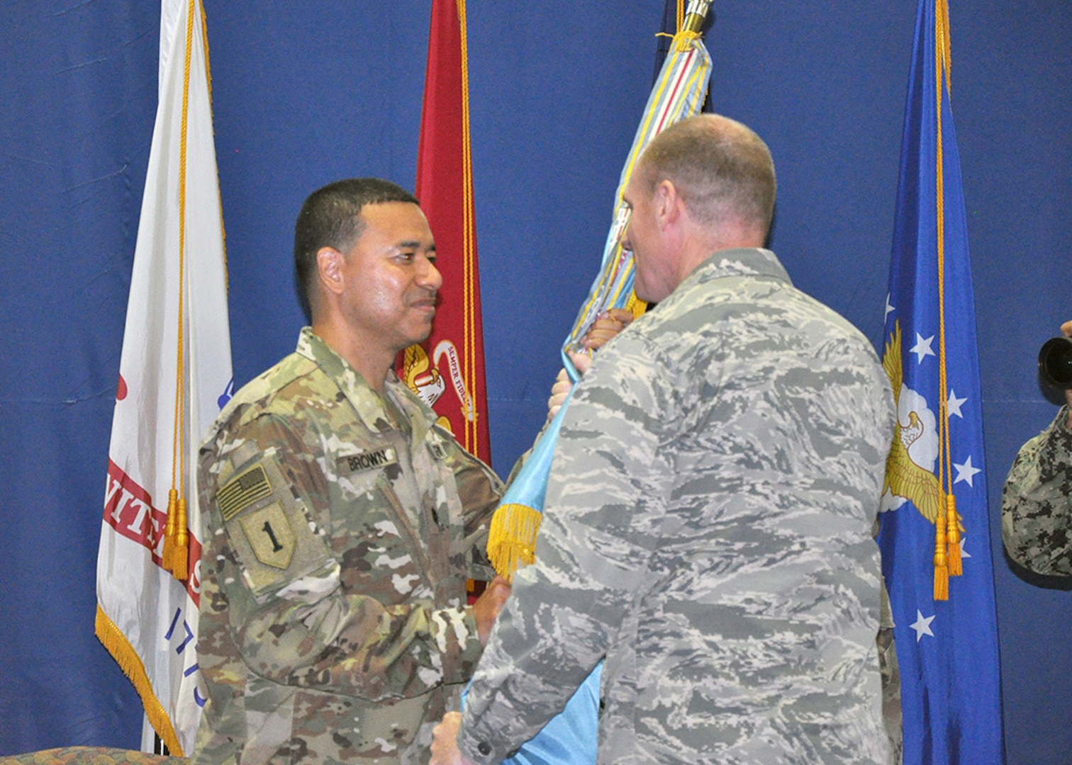 DLA Energy Commander Air Force Brig. Gen. Martin Chapin passes the DLA flag to the new DLA Energy Middle East Commander Army Lt. Col. Henry Brown, during a change of command ceremony at Naval Support Activity Bahrain June 27.  