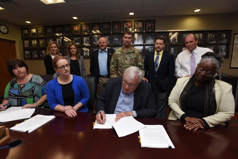 Tony Sloan,managing member of Marina at Rowena, LLC, signs the lease agreement for Lake Cumberland's Marina at Rowena during a signing ceremony July 5, 2017 at the district headquarters in the Estes Kefauver Federal Building at Nashville, Tenn. He is surrounded by Corps of Engineers Officials and fellow managing member Tom Allen.
