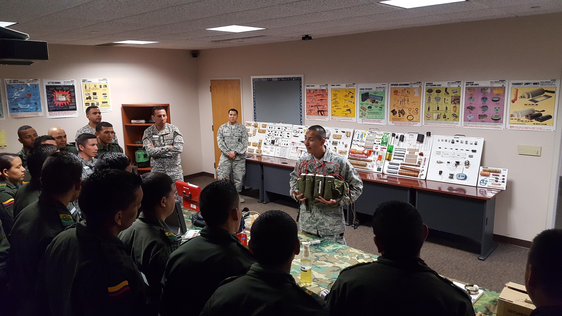 Tech. Sgt. Juan Ipatzi, 837th Training Squadron International Force Protection Flight instructor (center right) displays an explosive vest to students of Colombia's armed forces at a counter-terrorism symposium held at the Inter-American Air Forces Academy at Joint Base San Antonio-Lackland June 20. The symposium taught the students how to spot and counter bombs hidden inside commonplace objects.
